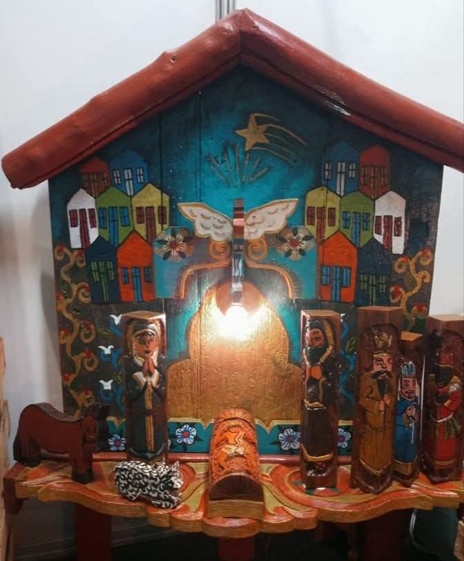 O mesmo oratório com a luz acesa, em outro ambiente, com as figuras do presépio em outra disposição