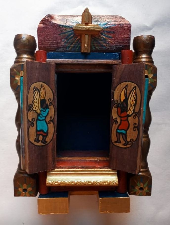 O mesmo oratório aberto, com o nicho vazio e um anjo pintado em cada porta