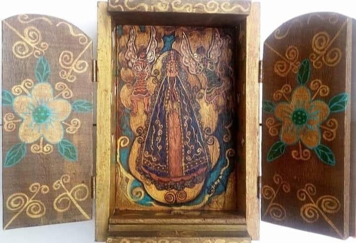Oratório aberto com Nossa Senhora Aparecida entre dois anjos ao centro e flores pintadas nas portas